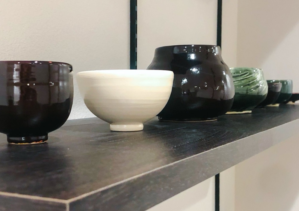 黒から緑のグラデーションで並ぶ器の棚